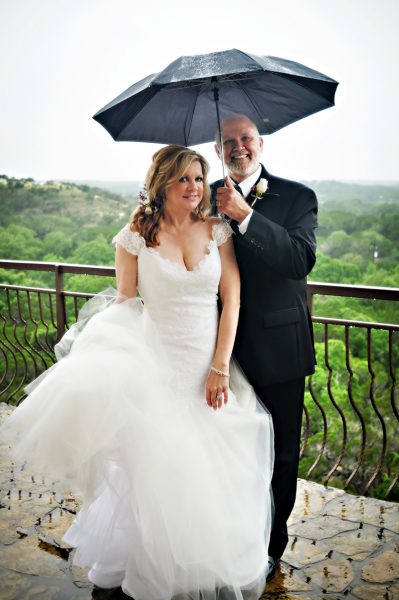 bride & groom with umbrella in the rain